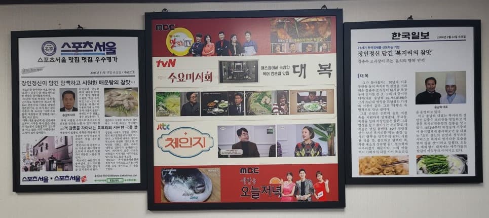 스포츠서울, 방송 프로그램 게시물, 한국일보 액자가 함께 걸려 있는 대복 매장 벽면